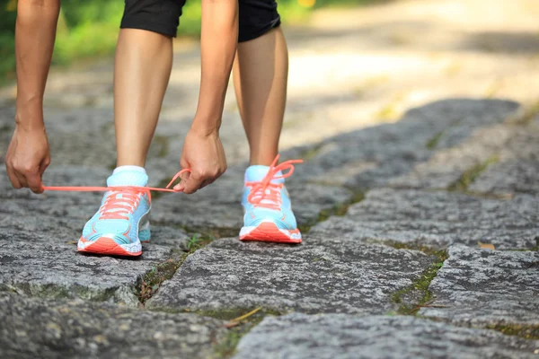 Mujer corredora atando cordones — Foto de Stock