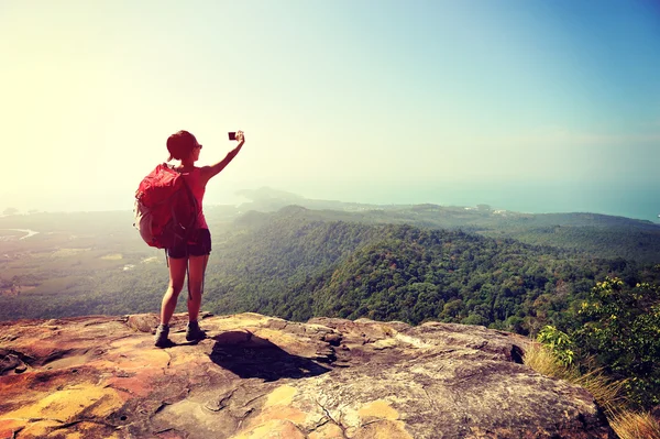 Mujer turista tomando fotos cima de la montaña — Foto de Stock