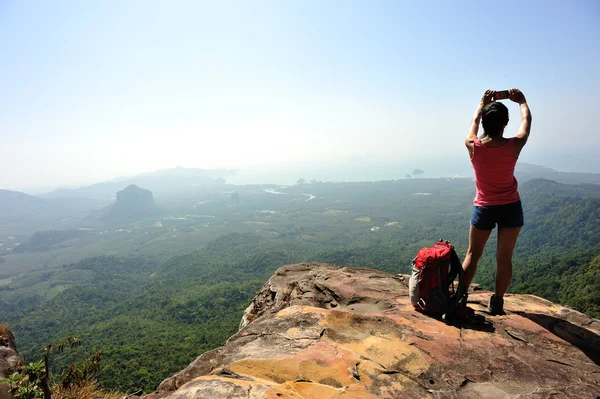 Mujer turista tomando fotos cima de la montaña — Foto de Stock
