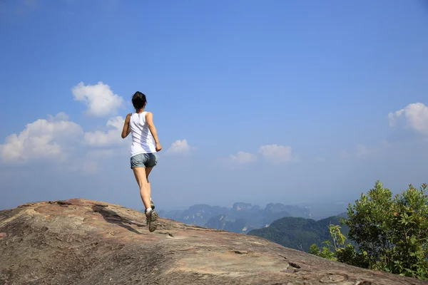 Jambes féminines courir sur la montagne — Photo