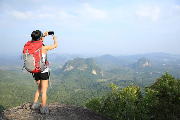 Mujer turista tomando fotos cima de la montaña — Foto de Stock