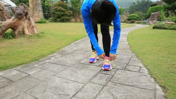 Woman runner tying shoelace — Stock Video