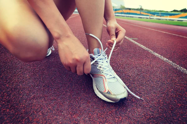 Kadın atlet bağlama ayakkabı bağı — Stok fotoğraf