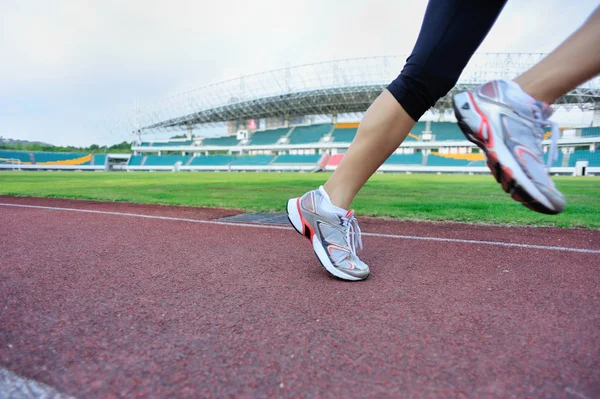 Gambe femminili fitness su pista stadion — Foto Stock