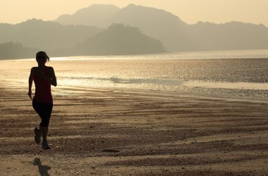 Deniz kenarında koşan bayan sporcu