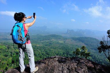 Uzun yürüyüşe çıkan kimse smartphone ile dağ üst
