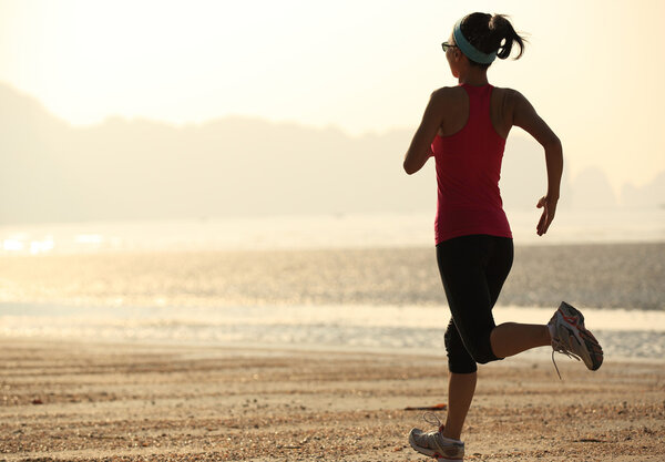 Female athlete running at seaside
