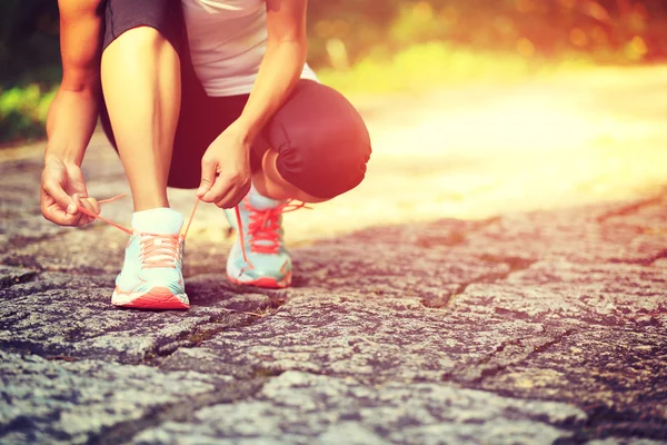 Female runner tying shoelaces — Stock Photo, Image