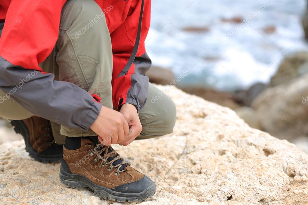 Female hiker hands tying shoelace