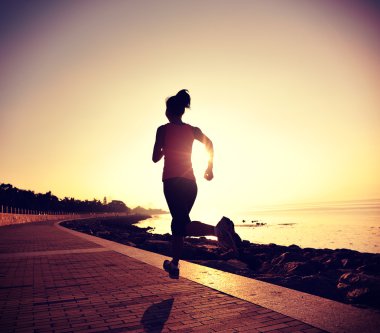 Deniz kenarında koşan bayan sporcu