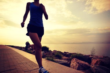 Deniz kenarında koşan bayan sporcu