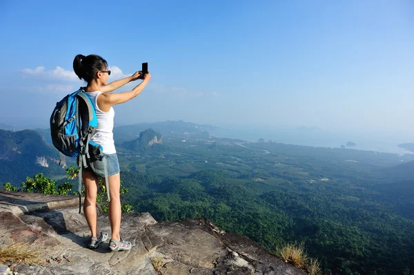 女性ハイカーは、スマート フォンで写真を撮る — ストック写真