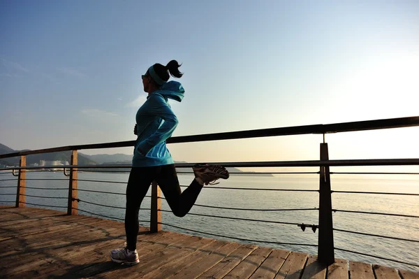 Жінка-спортсменка біжить на узбережжі — стокове фото