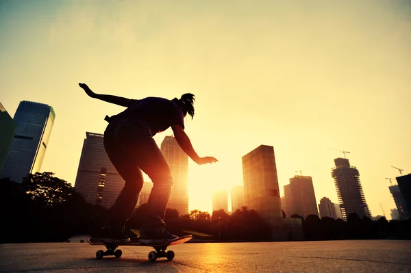 Skateboarder über der Sonnenaufgangsstadt — Stockfoto