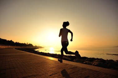 Deniz kenarında koşan bayan sporcu