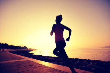 Deniz kenarında koşan bayan sporcu