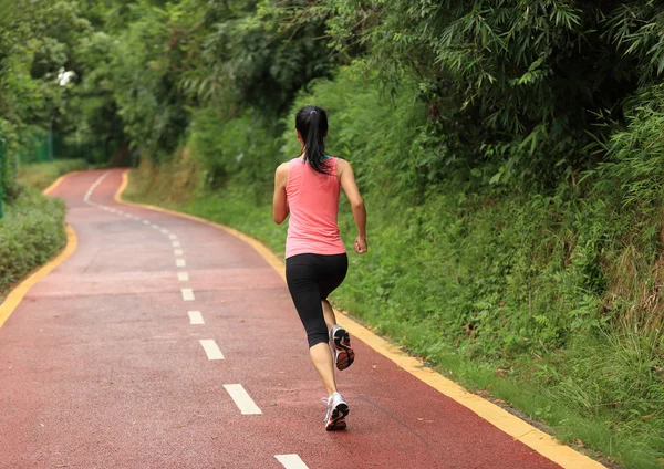 Fitness-Frau läuft auf Waldweg — Stockfoto