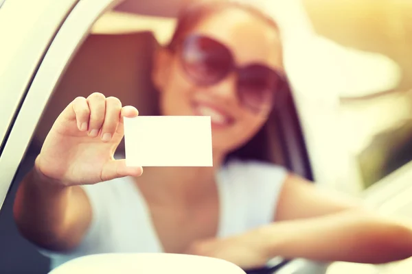 Mulher motorista com cartão em branco — Fotografia de Stock