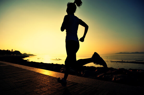 Female athlete running at seaside