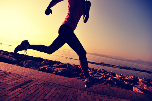 Female athlete running at seaside