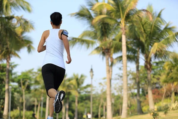 Mujer corriendo en el parque tropical — Foto de Stock