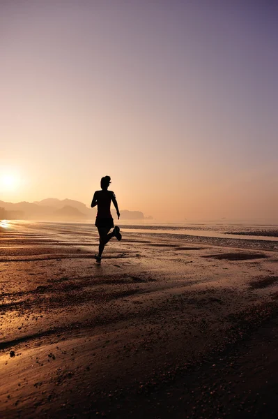 Feminino correndo silhueta na praia — Fotografia de Stock