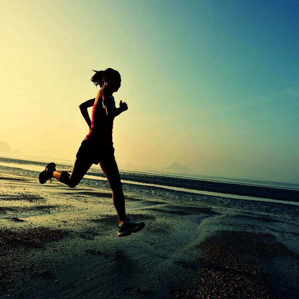 Silueta femenina corriendo en la playa —  Fotos de Stock