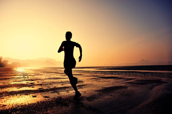 Silueta femenina corriendo en la playa — Foto de Stock