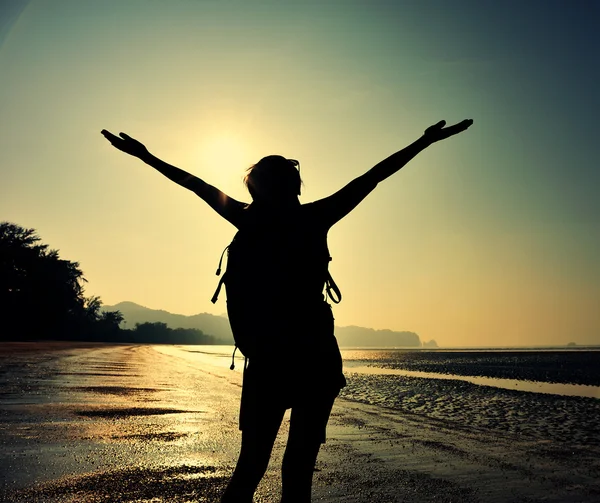 Cheering female silhouette at sunset beach — Stock Photo, Image