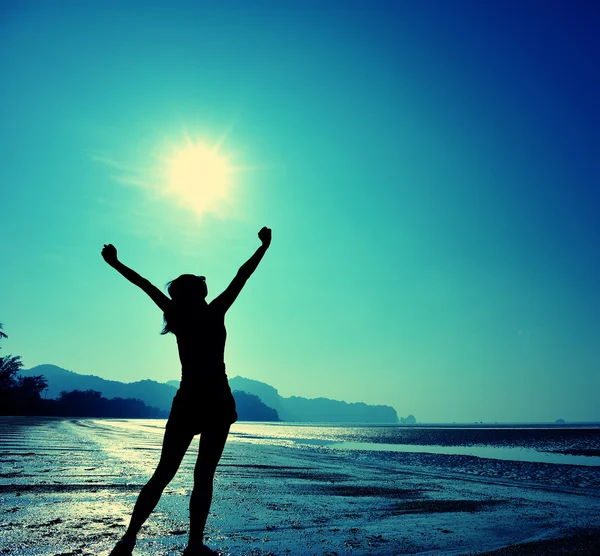 Cheering female silhouette at sunset beach — Stock Photo, Image