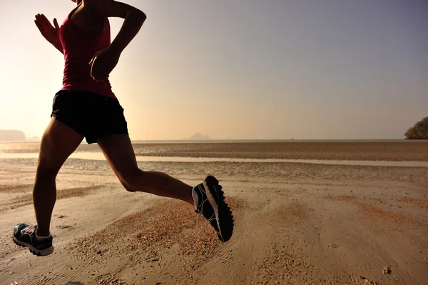 Silueta femenina corriendo en la playa —  Fotos de Stock