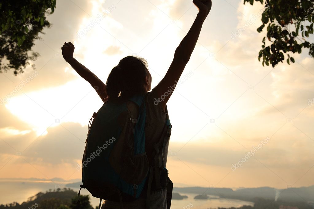 Cheering woman hiker on mountain top