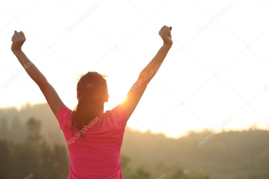 Cheering woman hiker on mountain top