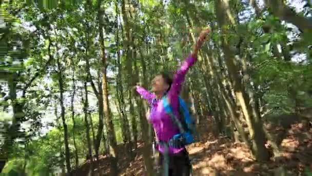 Азиатка с распростертыми объятиями в лесу — стоковое видео