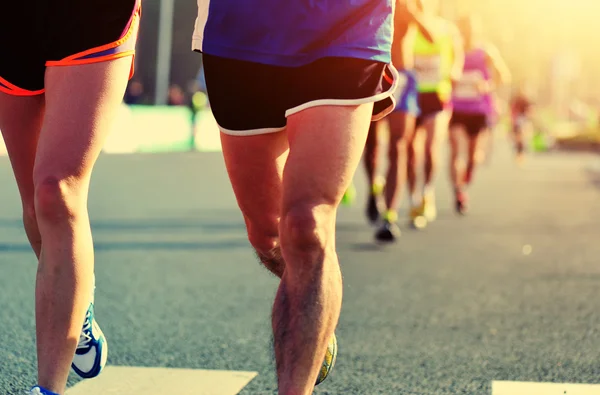 Maratón atletas piernas corriendo en la carretera — Foto de Stock