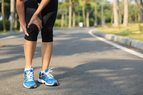 女子赛跑运动员与受伤的腿 — 图库照片