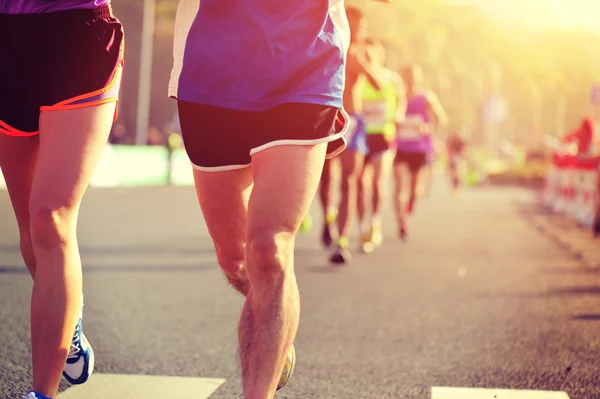 Maratón atletas piernas corriendo en la carretera — Foto de Stock