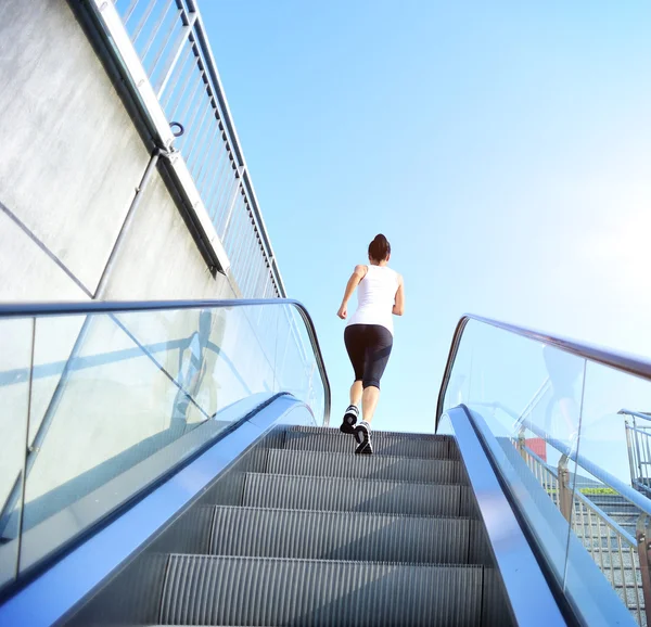 Femme courant sur escaliers roulants — Photo