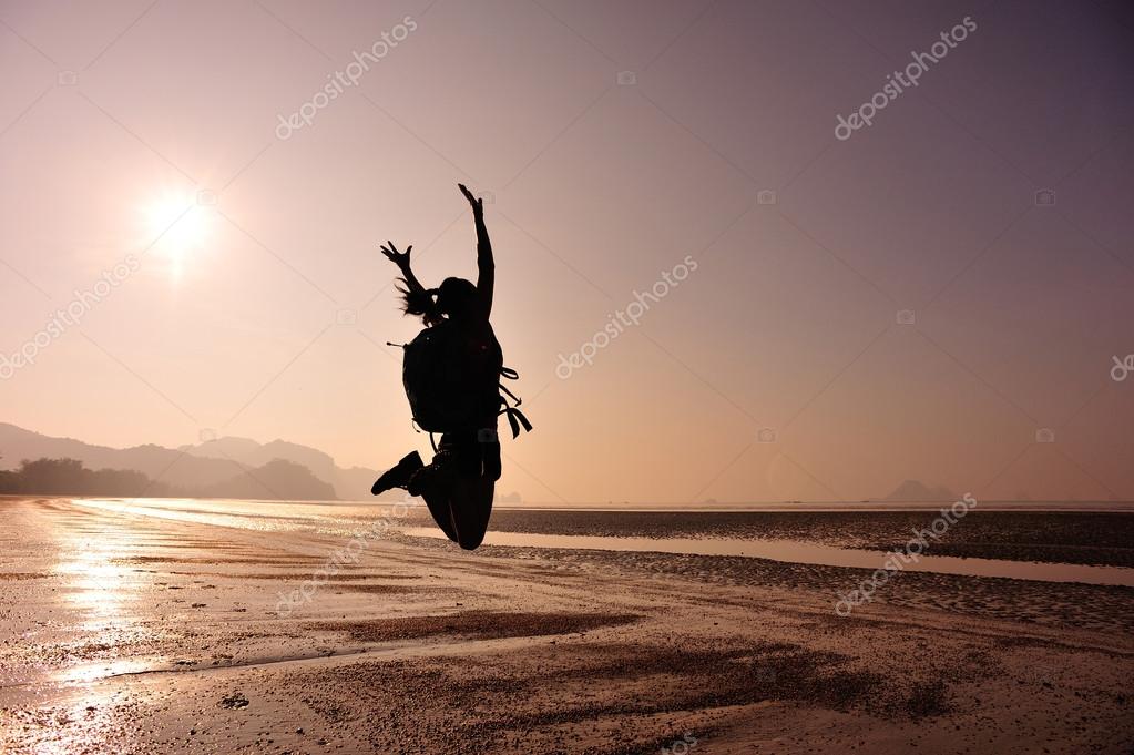 Cheering woman hiker jumping