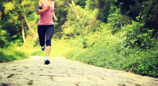 Female athlete running in forest — Stock Photo, Image