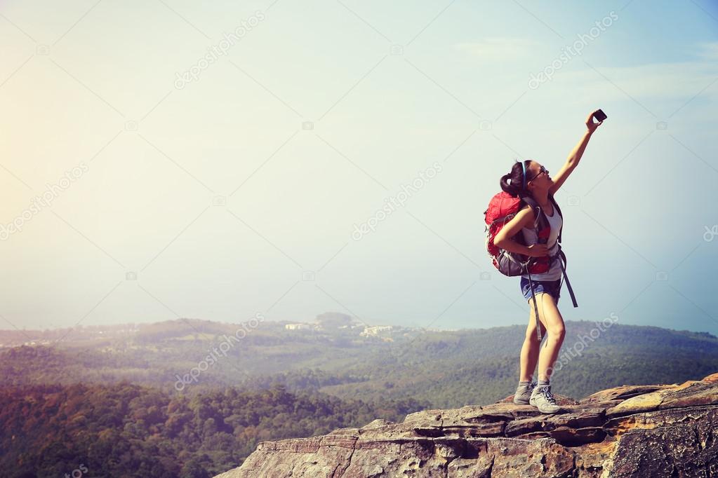 woman hiker taking photo with smartphone