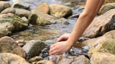 Uzun yürüyüşe çıkan kimse scooping avuç içi su ile