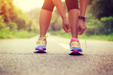 Genç Asyalı kadın bağlama ayakkabı bağı