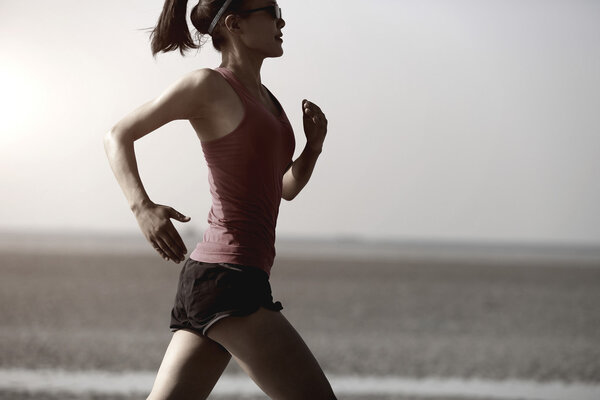 Young woman running at beach