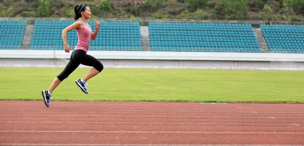 Fitnessfrau läuft auf der Strecke — Stockfoto