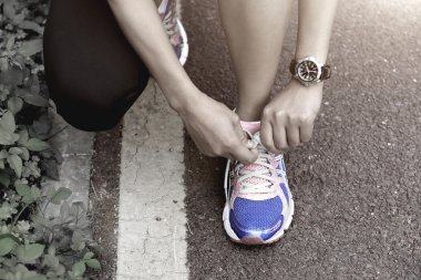 Genç kadın bağlama ayakkabı bağı