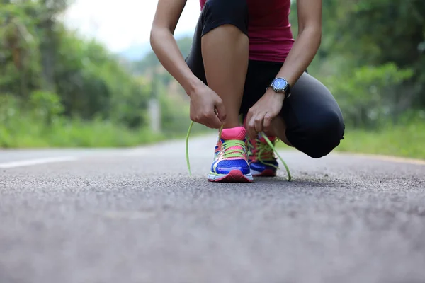 Mujer joven atando cordones —  Fotos de Stock