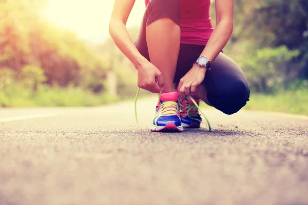 Mujer joven atando cordones — Foto de Stock