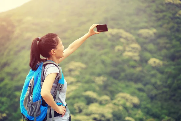 Jeune femme randonneuse prenant des photos — Photo