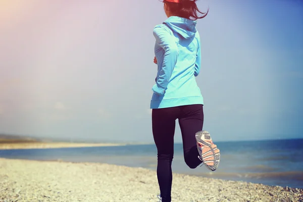 Runner athlete running on stone beach — Stock Photo, Image